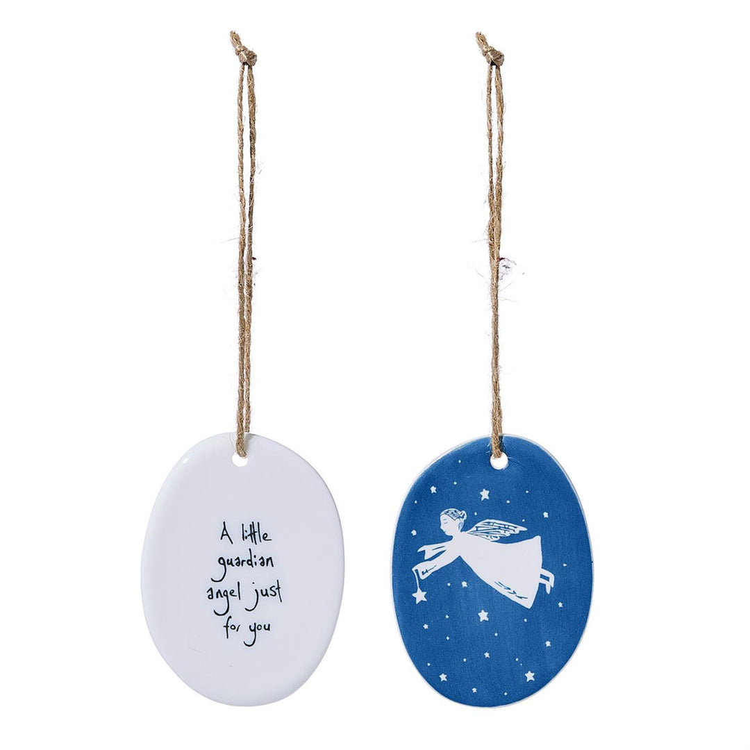 Two oval porcelain ornaments: one white reading “A little guardian angel just for you,” and one blue with a white angel and star pattern.