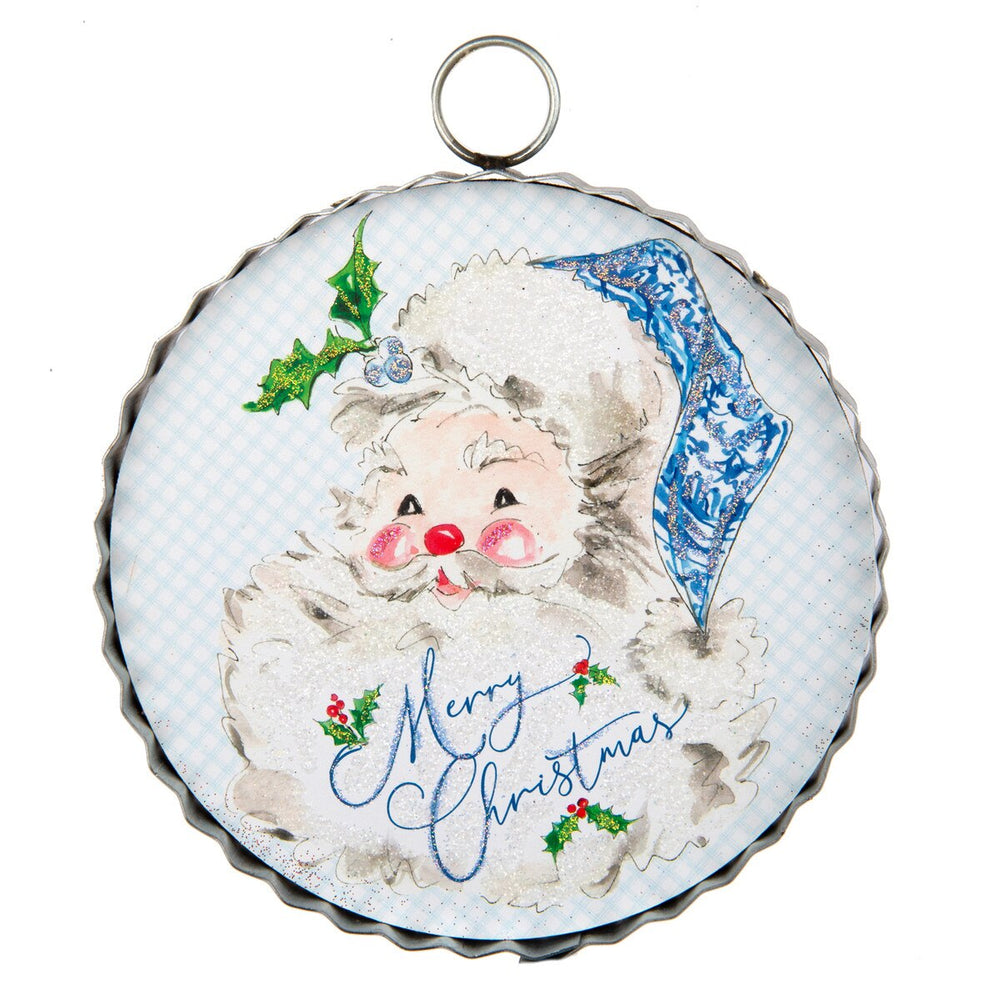 Beck’s Blue Santa round metal ornament featuring a Rosanne Beck illustration of Santa Claus with a blue hat, holly, and “Merry Christmas” text.