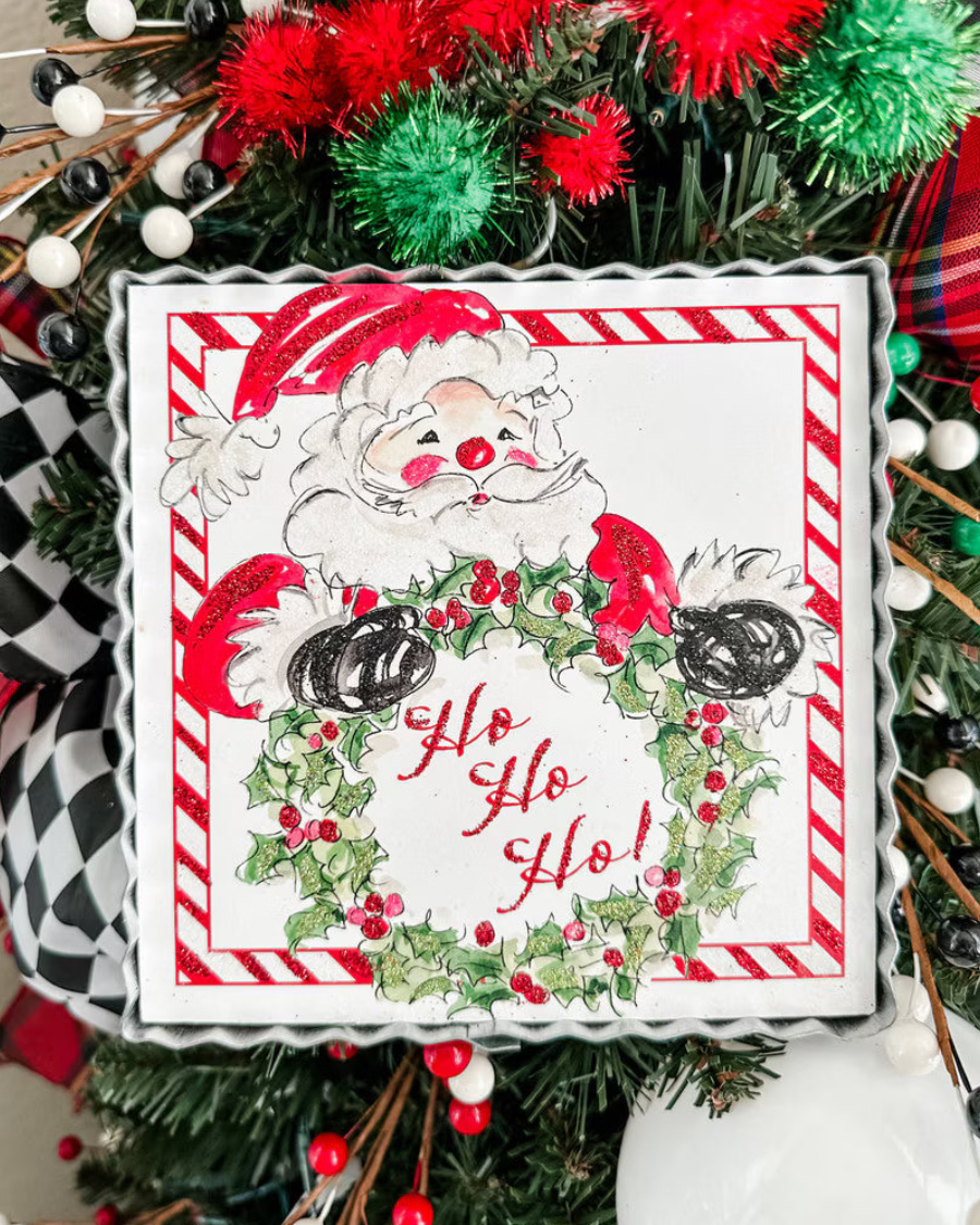 Mini Gallery Art Beck’s HoHoHo Santa square metal sign featuring festive Santa artwork, holly wreath, “Ho Ho Ho!” text, and red-and-white striped border.
