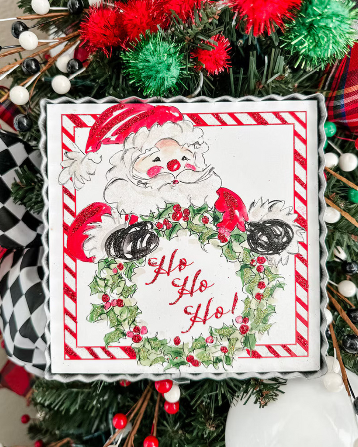 Mini Gallery Art Beck’s HoHoHo Santa square metal sign featuring festive Santa artwork, holly wreath, “Ho Ho Ho!” text, and red-and-white striped border.