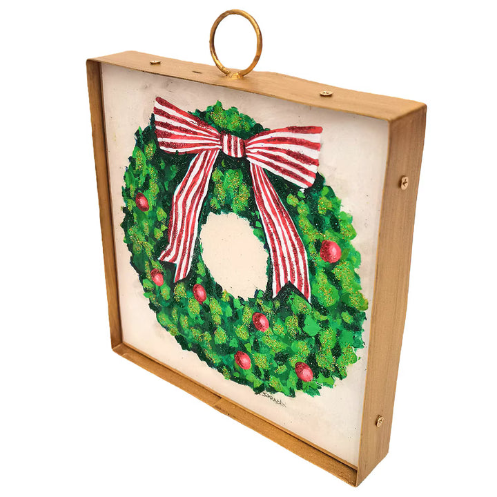 Mini Gallery Art Green Wreath with Red Ornaments, a square wall art piece featuring a painted Christmas wreath with red ornaments and a red-and-white striped bow, set in a gold-toned metal frame with a top hanging loop.