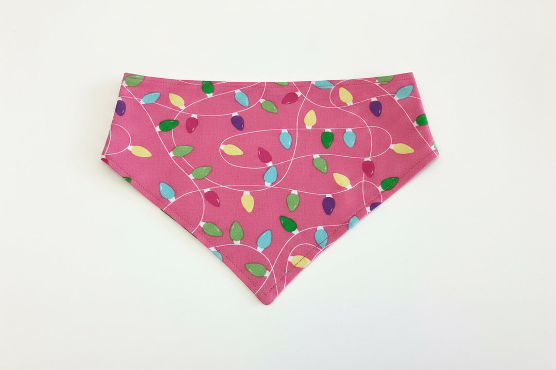 Pink Light It Up triangular holiday dog bandana with multicolored Christmas light bulbs and white cord outlines, available in multiple sizes.