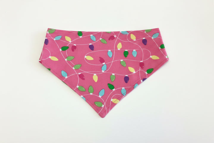 Pink Light It Up triangular holiday dog bandana with multicolored Christmas light bulbs and white cord outlines, available in multiple sizes.