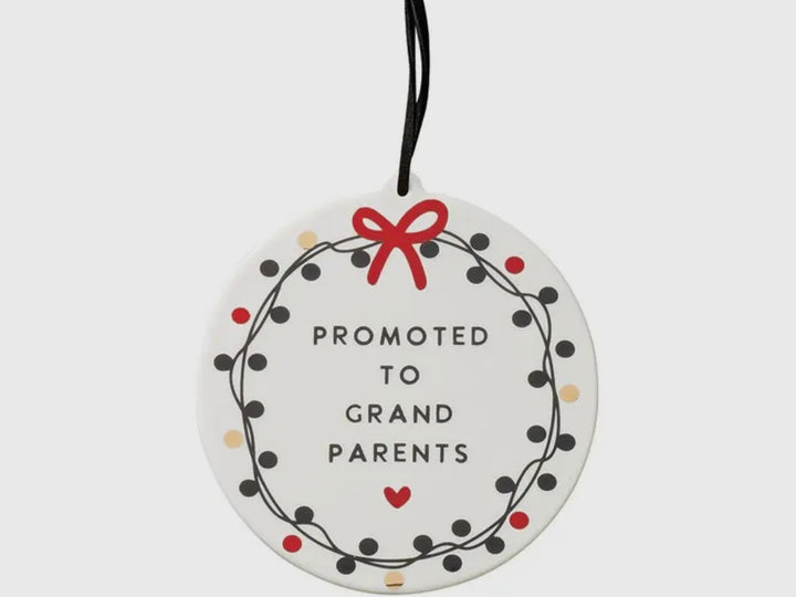 Round white “Promoted To Grandparents” ornament with a black dotted wreath, red top bow, and red bottom heart.