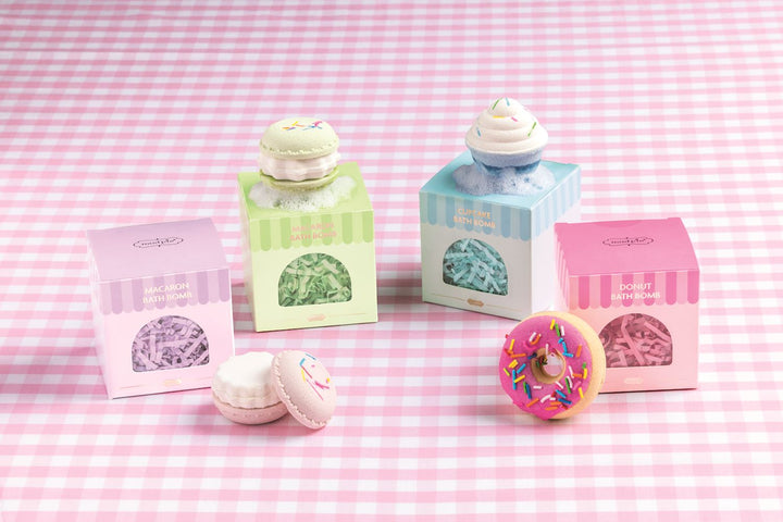 Café Bath Bomb set with four pastry-shaped bath bombs: a macaron, a cupcake, and a donut, packaged in individual square boxes.