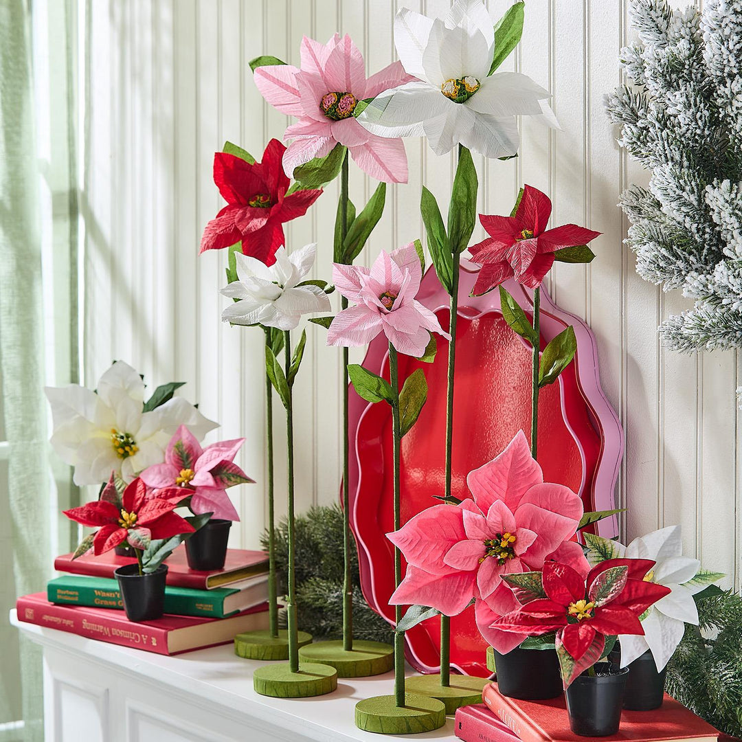 Festive Flower Market Faux Poinsettia stems in red, pink, and white, available in small pots and on circular bases.