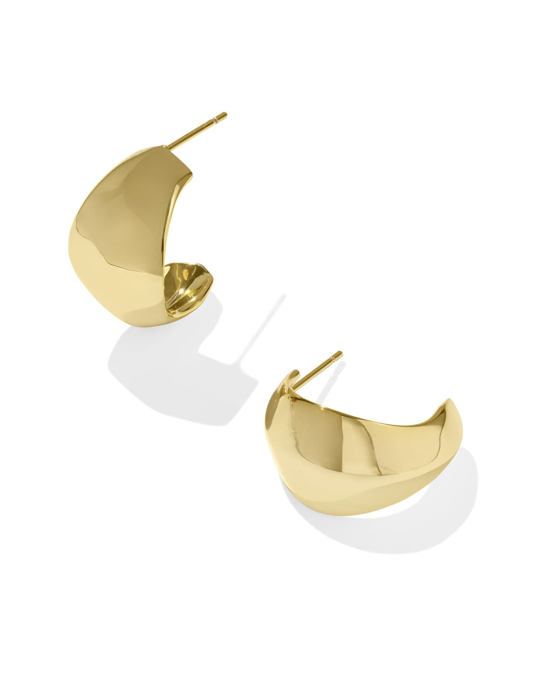 The Krista Gold Metal Hoops by Kendra Scott are chunky, crescent-shaped 14k yellow gold earrings with post backs. Sizes: S, M, L.