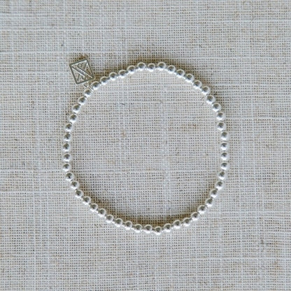 Shiny Silver Bracelet with delicate silver beads and engraved square charm; hypoallergenic. Available in S, M, L sizes.