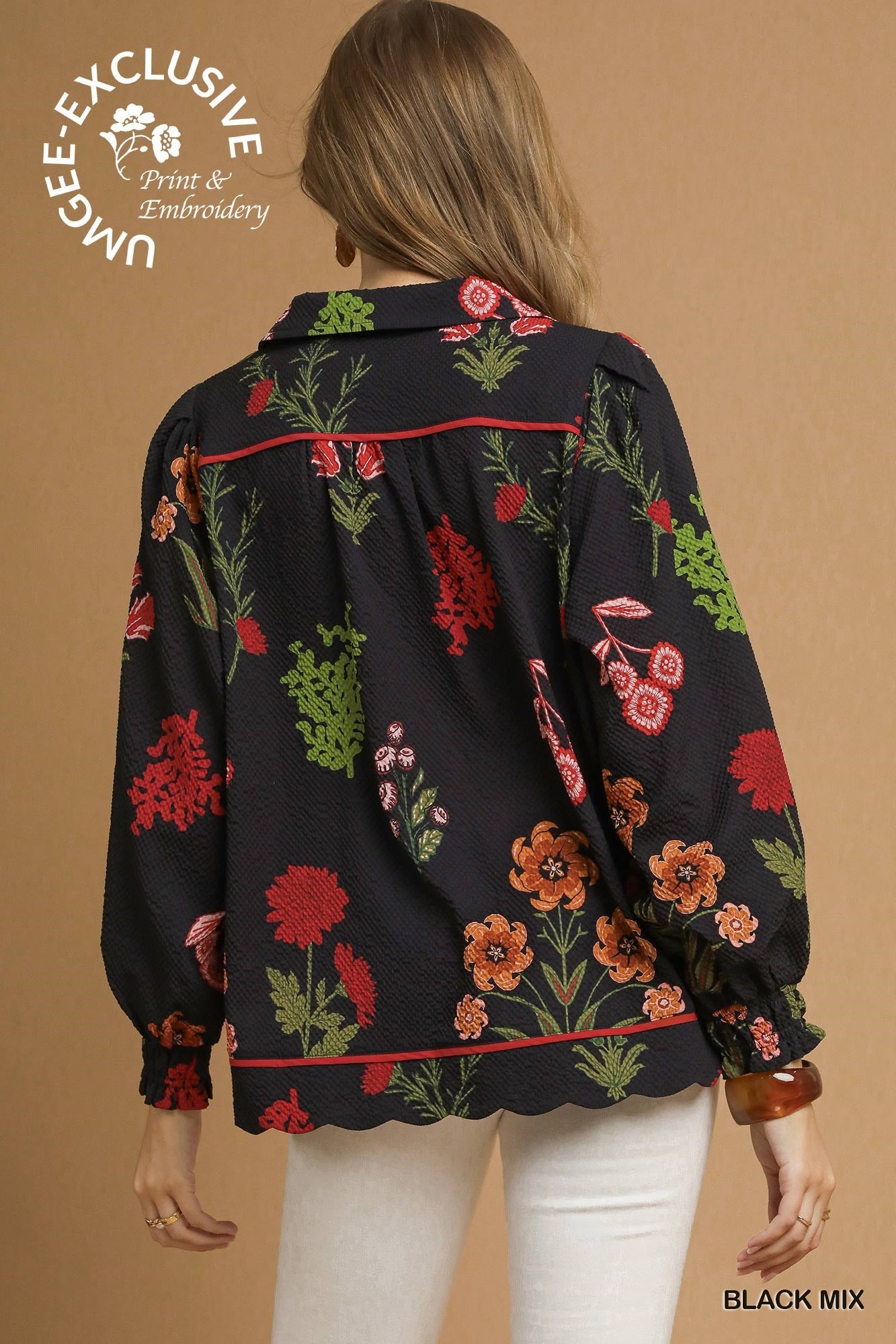 Black textured top with red, green, and orange floral embroidery, scalloped hem, puff sleeves. Sizes: XS-XXL.