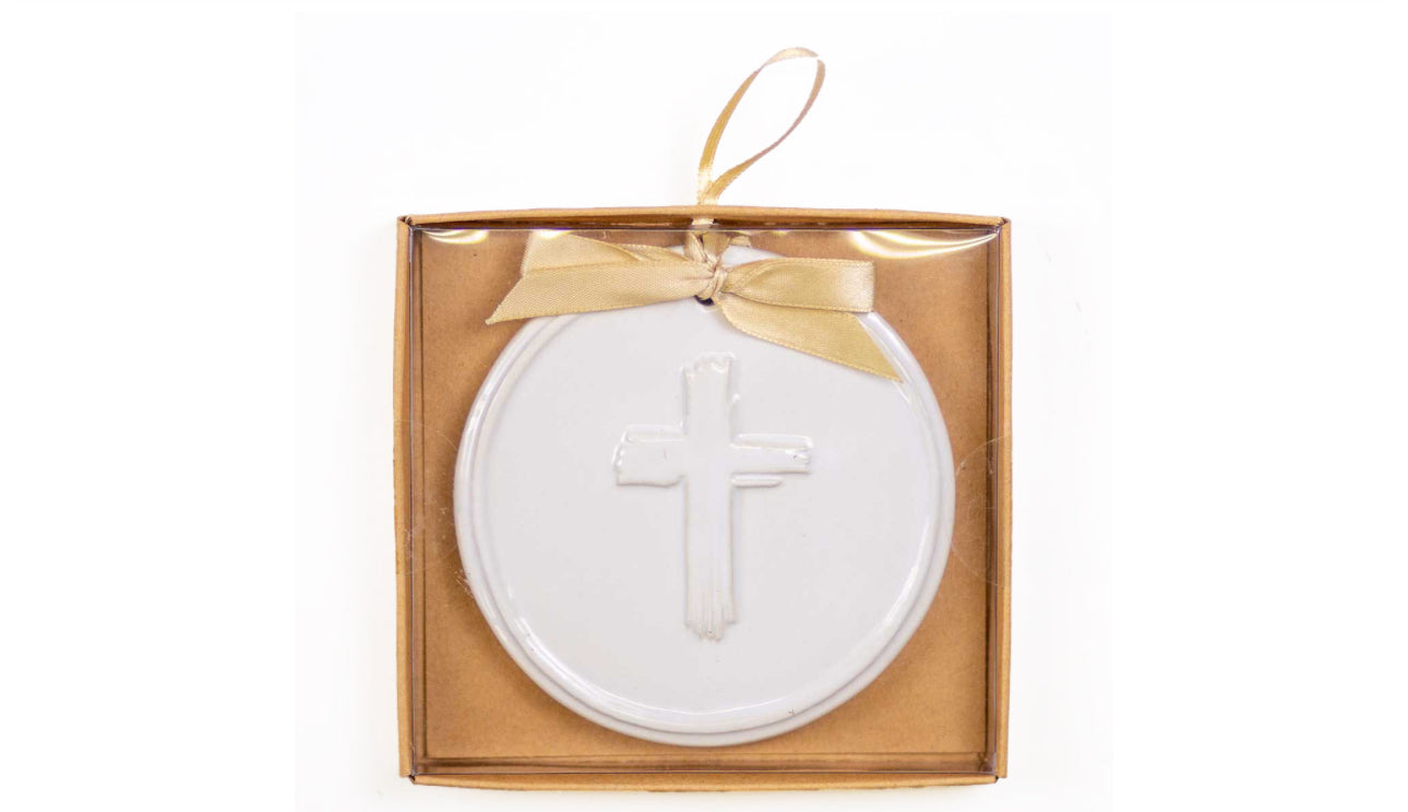 White ornament featuring a cross and tan satin bow in box