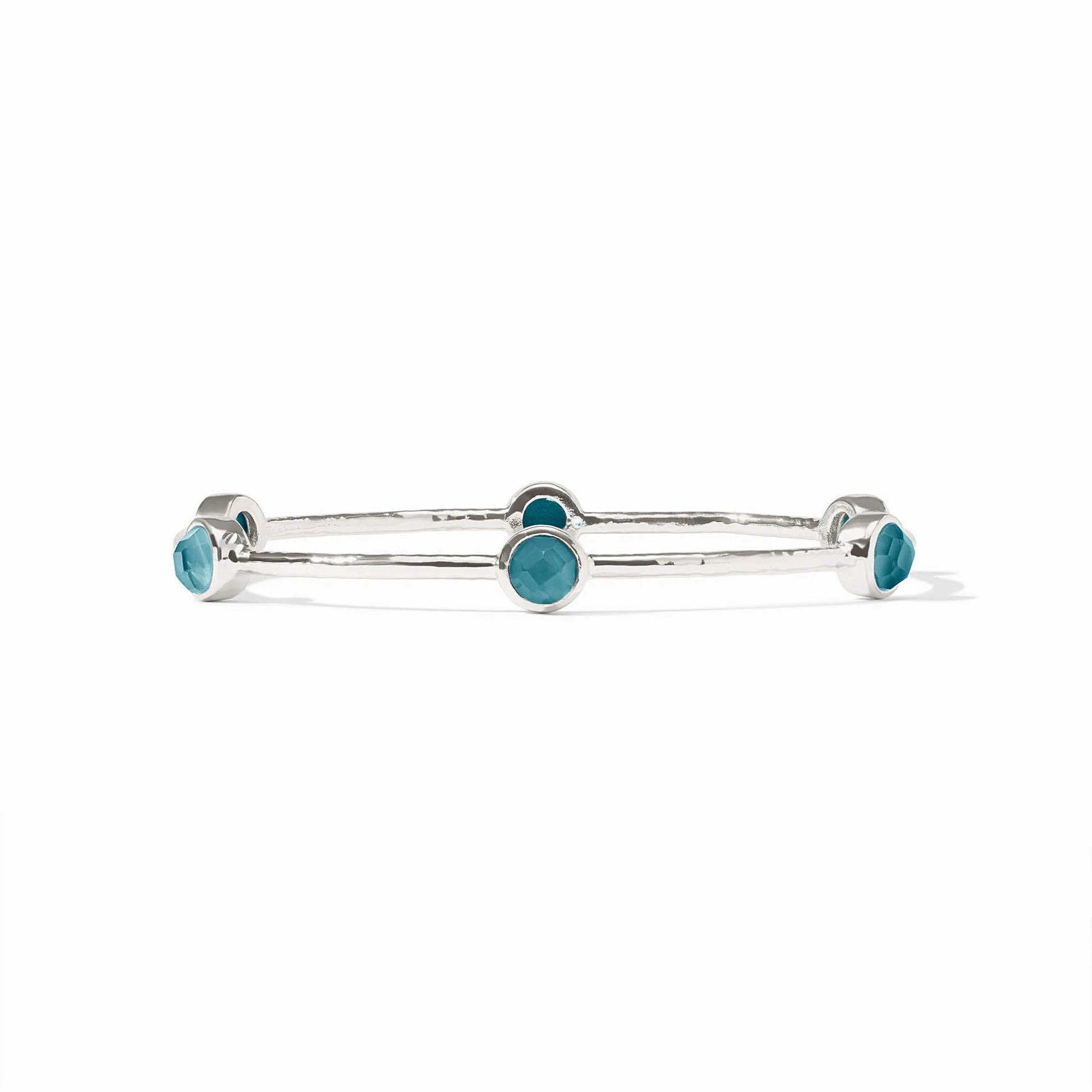 Silver bangle with five round blue bezel-set stones. Available in small, medium, and large sizes.