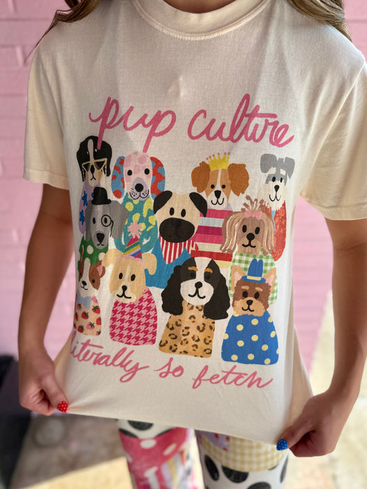 Cream Comfort Colors tee with illustrated pop culture dogs, “pup culture,” and “literally so fetch” in pink; sizes S-XXL.