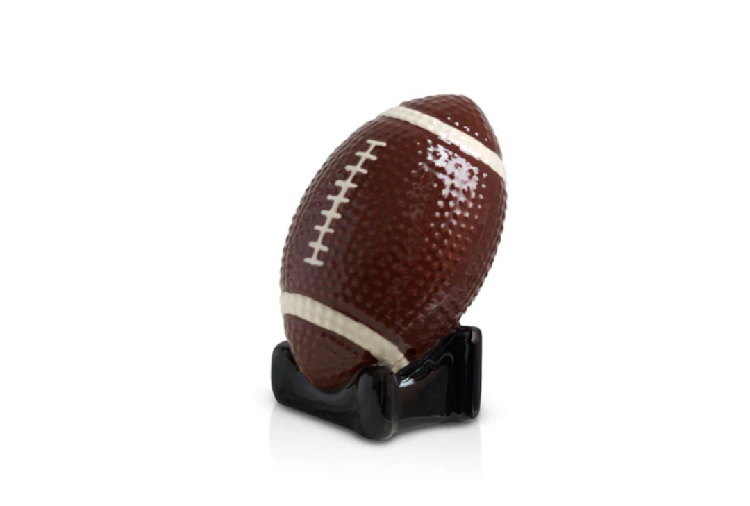 Ceramic football from the Nora Fleming Minis collection. Detailed with white stripes and laces. Displayed on a black stand. Available sizes: Small.