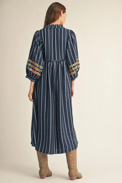 Floral Embroidered Midi Dress in navy blue with white vertical stripes and colorful embroidery on the sleeves. Available in sizes XS-XL.
