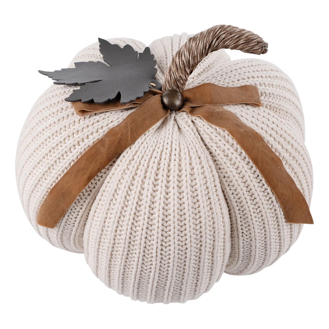 Cream knit pumpkin with a brown faux leather ribbon, twine stem, and metal leaf accent; available in multiple sizes.
