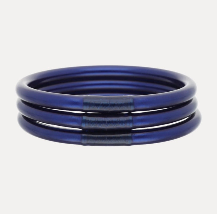 Set of three metallic blue Midnight All Weather Bangles with textured darker blue accents, waterproof and handcrafted in Thailand. Available in small, medium, and large sizes.
