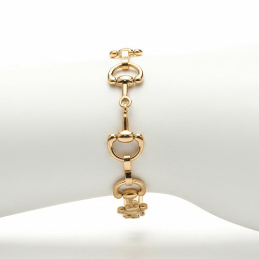 The Harry Gold Horse Bit Toggle Bracelet features large, rounded links and a horse bit design with a secure toggle closure. Available in small, medium, and large sizes.