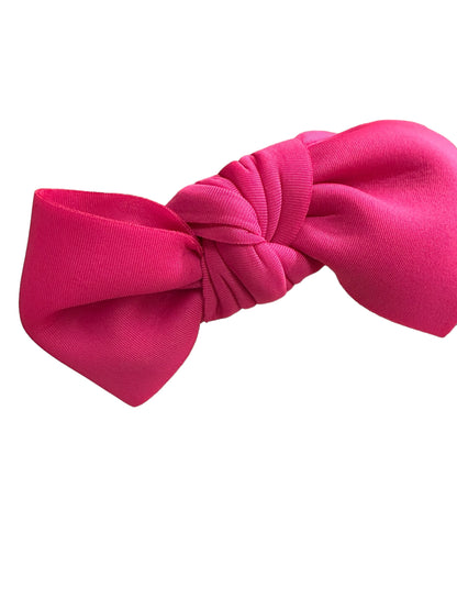 Bright pink Bow Headband with twisted knot center. Available in small, medium, and large sizes.