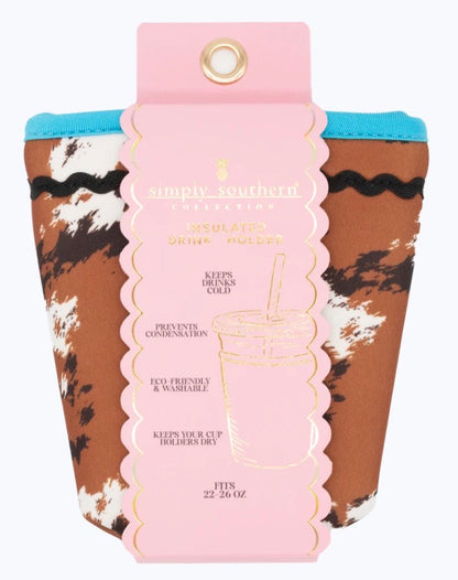 Cow Print Insulated Drink Holder with brown and white pattern, blue trim, and pink tag. Fits 22–26 oz cups. Eco-friendly, washable, and reusable.