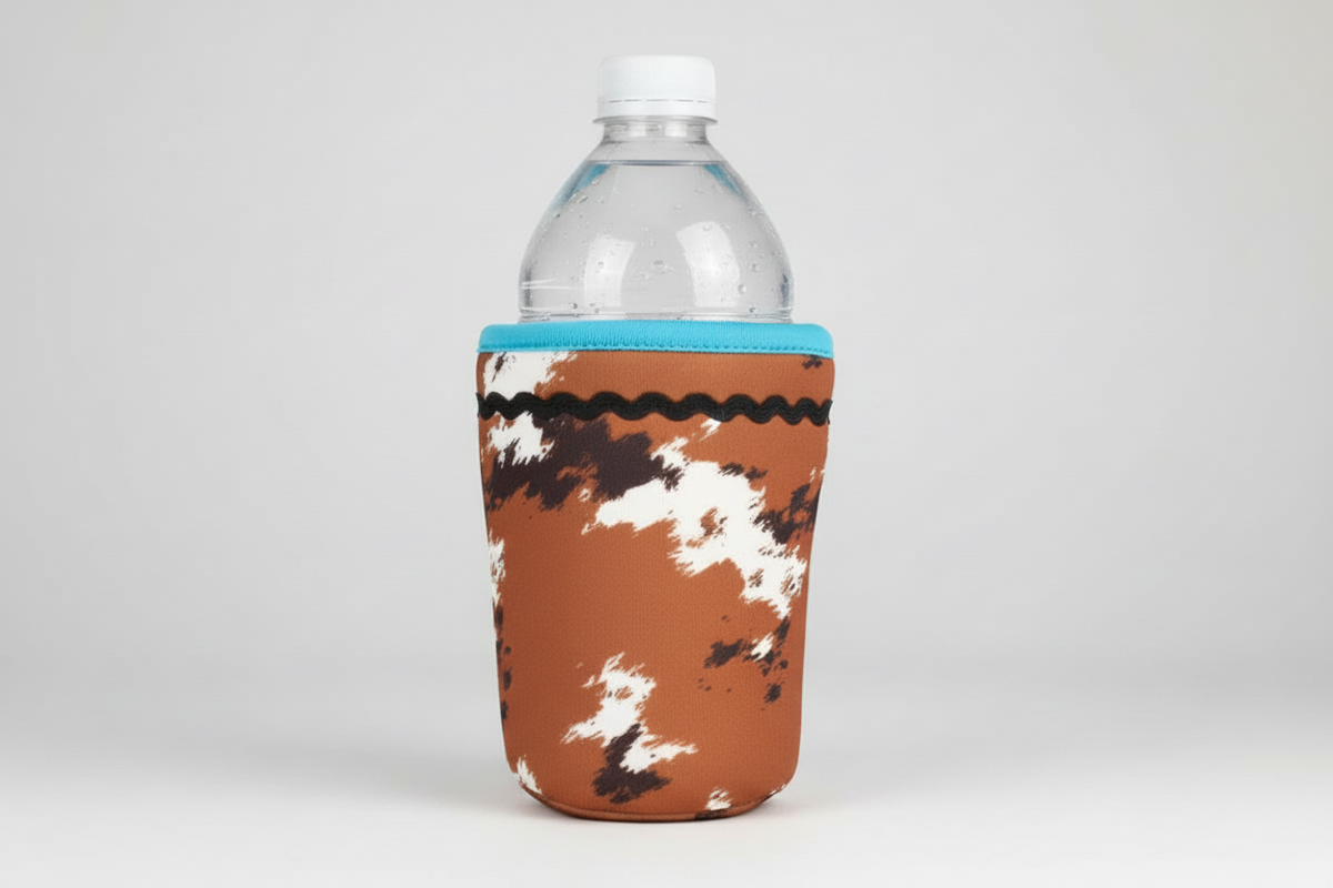 Cow Print Insulated Drink Holder with blue trim and black wavy line decoration, fits clear plastic water bottles; available in small, medium, and large sizes.