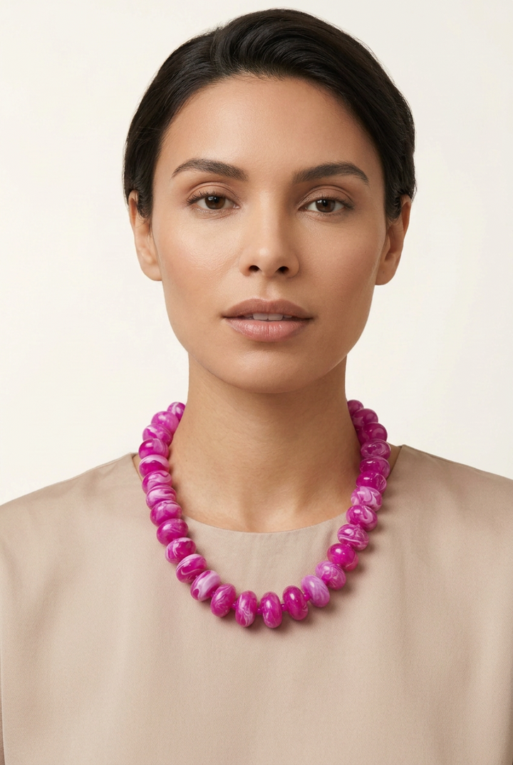 Oblong magenta-and-white marbled bead necklace.