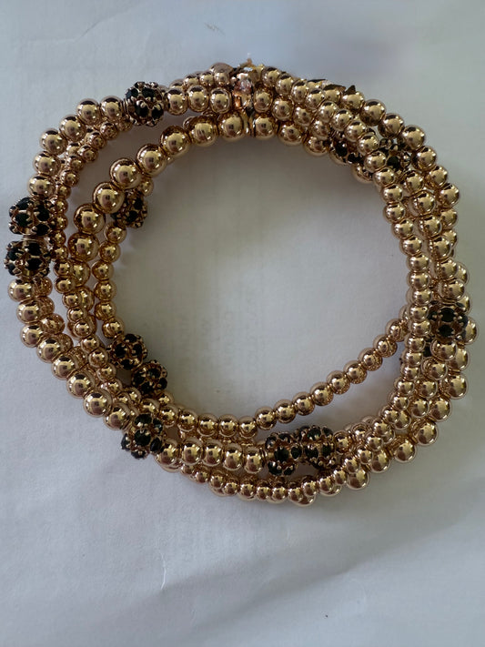 The Luda Emerald Bracelet: coiled gold beads with green bead clusters. Available in S, M, and L sizes.