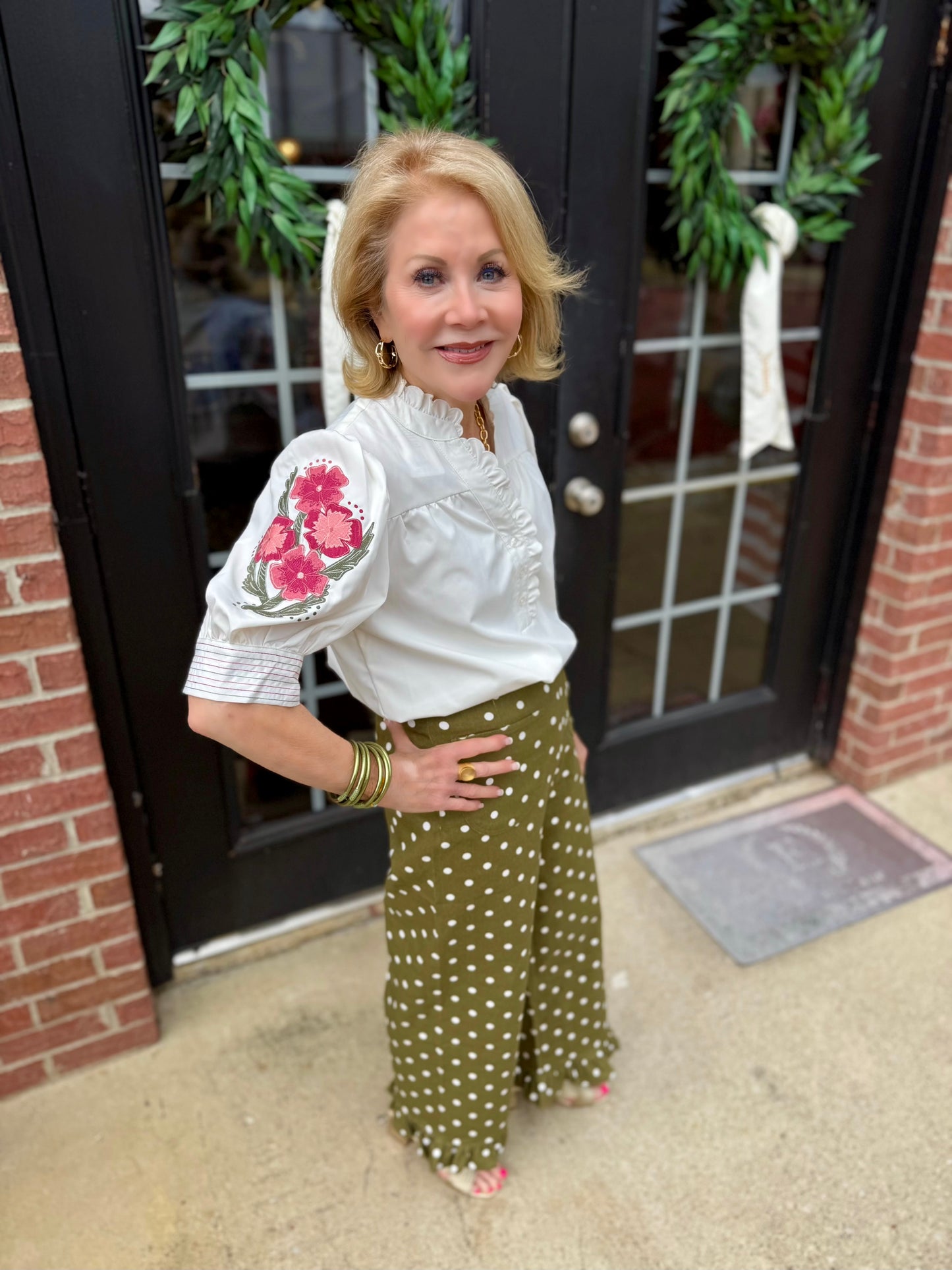 White blouse with floral embroidery on sleeves; available in sizes XS–XL.