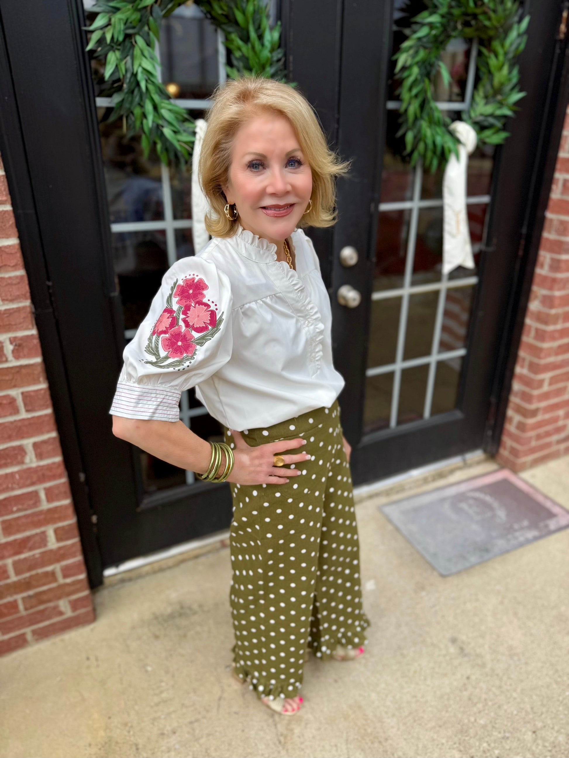 White blouse with floral embroidery on sleeves; available in sizes XS–XL.
