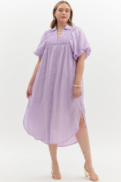 Flowing Lavender Midi Dress with puff sleeves, smocked bodice, collar, textured fabric. Available in sizes XS–XL.