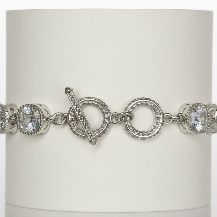 Jason Silver Clear Crystal Tennis Bracelet with round white gemstones, toggle clasp, and intricate detailing around stones and clasp. Available in multiple sizes.