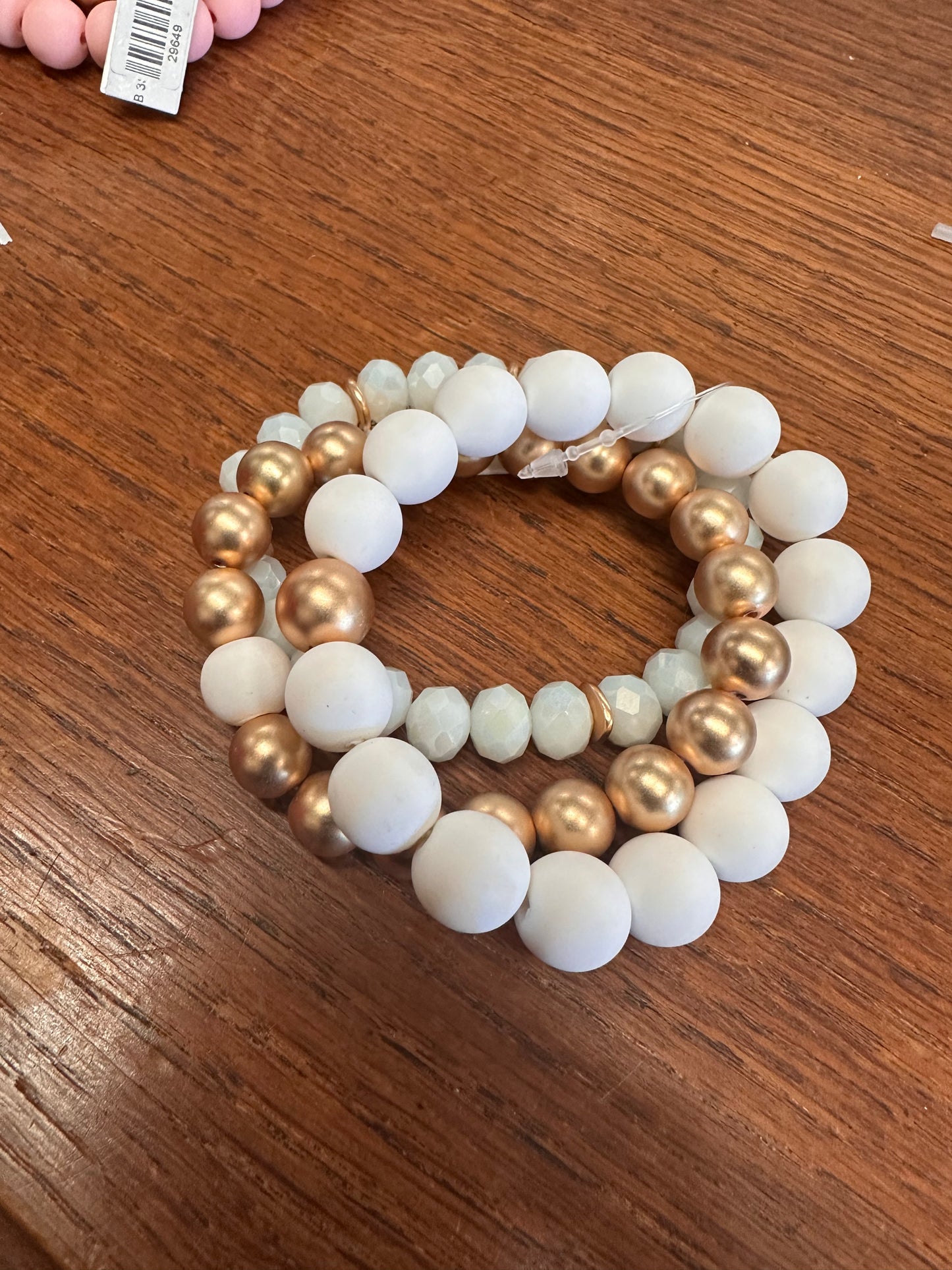 This product is a 12MM Clay Ball Bracelet offering an appealing blend of cream-colored and gold pearls. It displays an alternate arrangement pattern, creating visual interest. The bracelet is exclusively crafted, demonstrating a circular shape design.