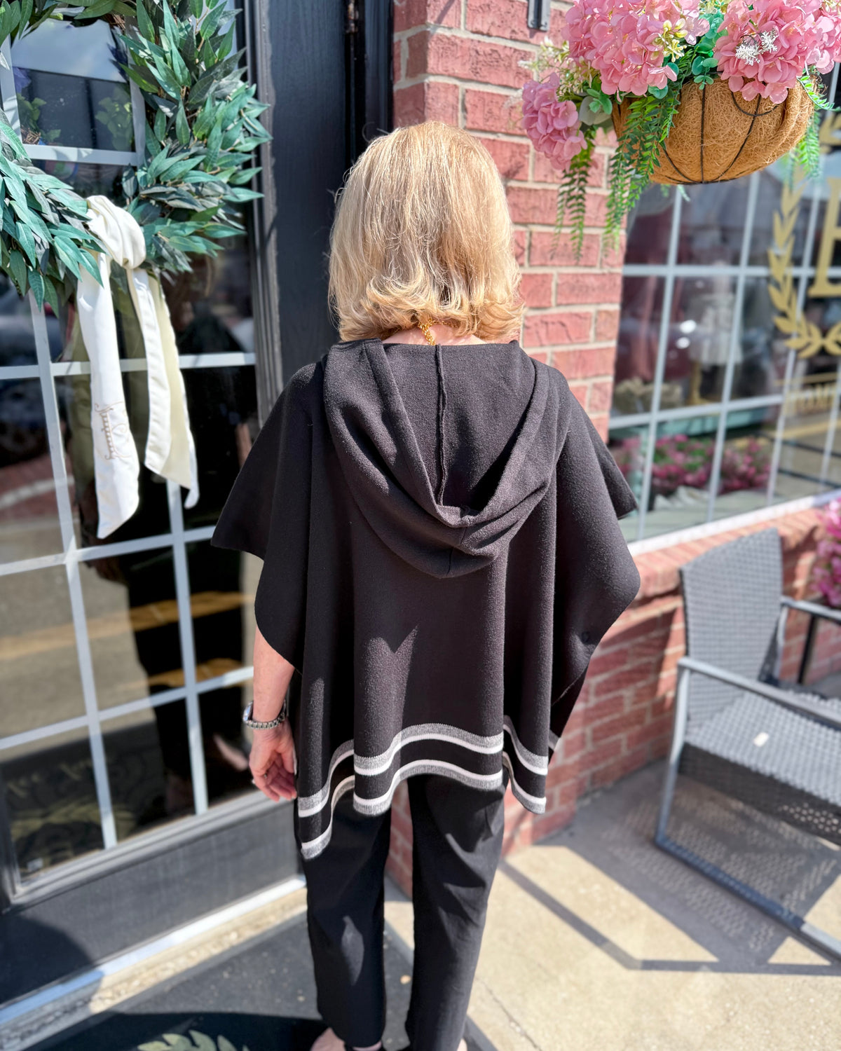 Aspen Stripe Hoodie Poncho: black with white stripes, hooded, designed for layering. Available in sizes XS-XL.