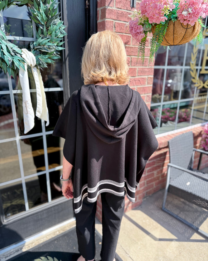 Aspen Stripe Hoodie Poncho: black with white stripes, hooded, designed for layering. Available in sizes XS-XL.