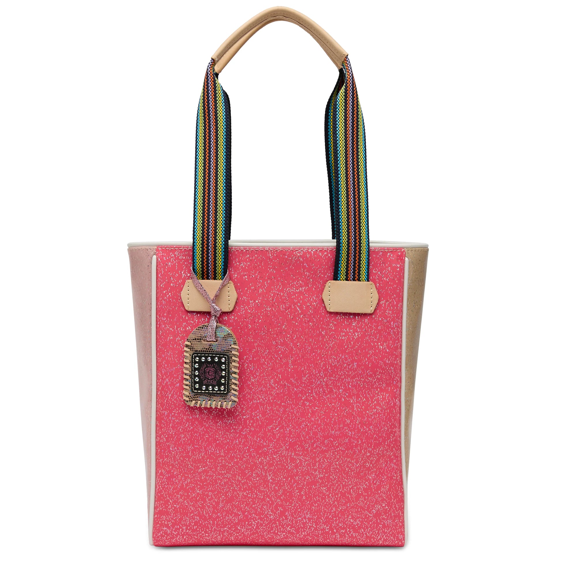 The Chica Tote, Bae has a pink glittery design, tan handles, rainbow-striped shoulder straps, and a beaded decorative tag. Available sizes: small, medium, large.
