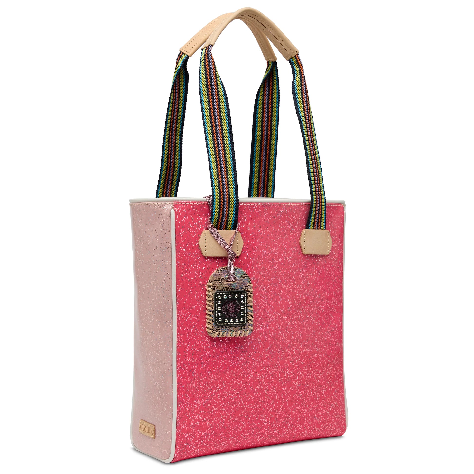Pink multicolored glitter Chica Tote, Bae with rainbow-striped handles, tan leather accents, and a square keychain. Leather-trimmed. Available in small, medium, and large sizes.