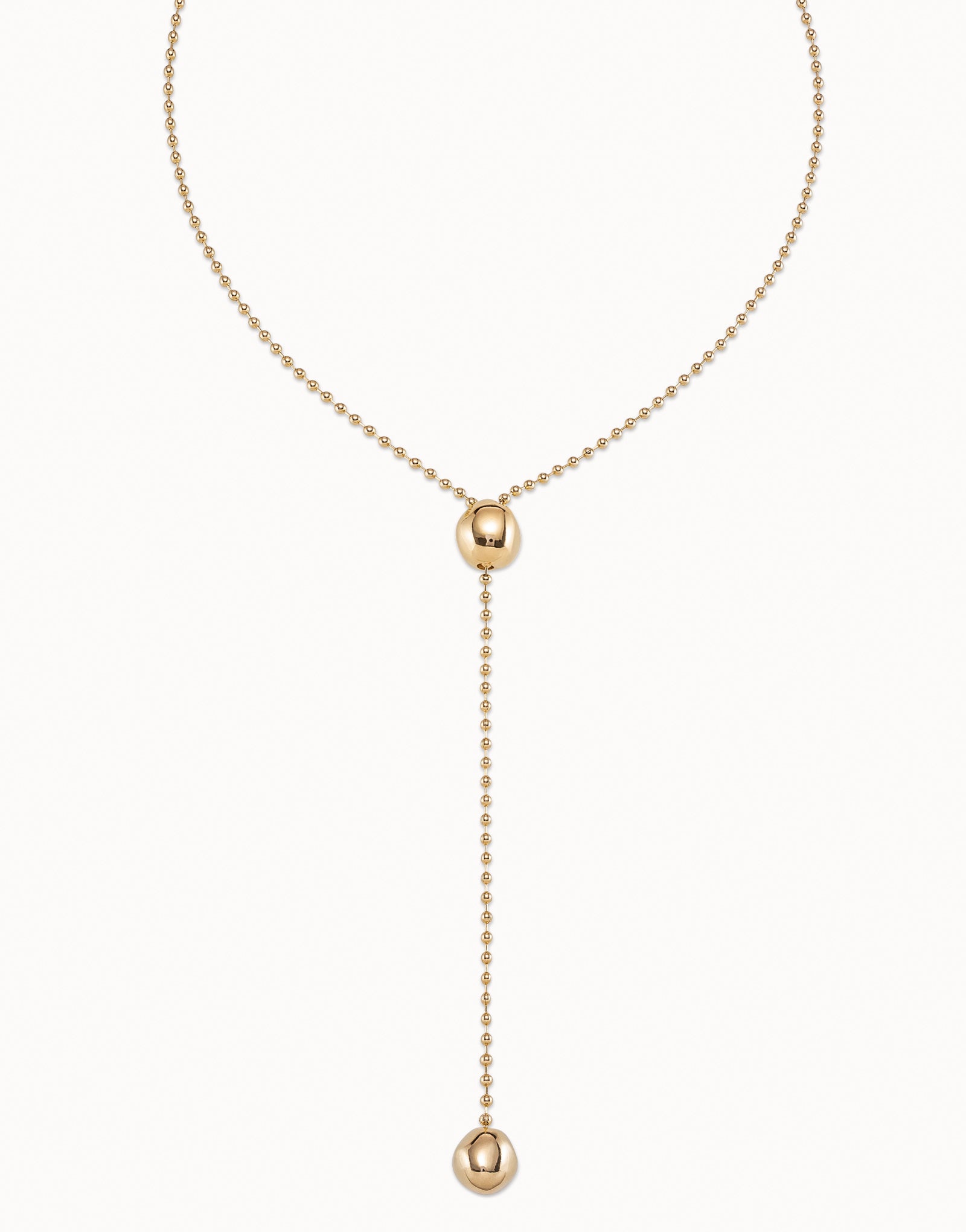 Long Adjustable Chain Necklace, handcrafted in Spain and plated in 18k gold. Features a beaded chain with a central bead, drop chain ending with a larger bead accent, and an adjustable clasp. Available in multiple sizes.