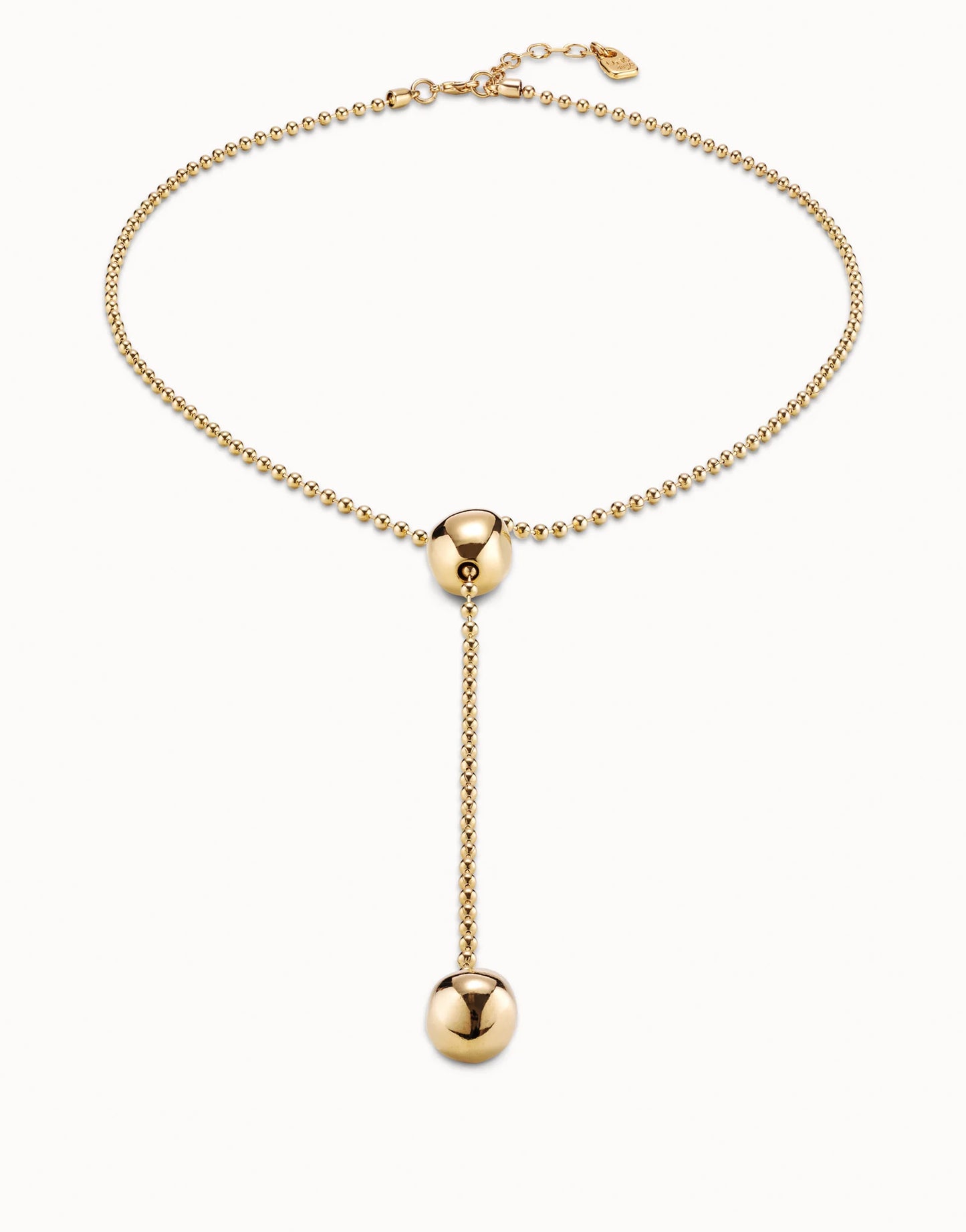 Handcrafted in Spain, the Long Adjustable Chain Necklace features a beaded gold chain with a central gold sphere and a larger gold sphere at the end of a vertical drop. Sizes available: one size adjustable.