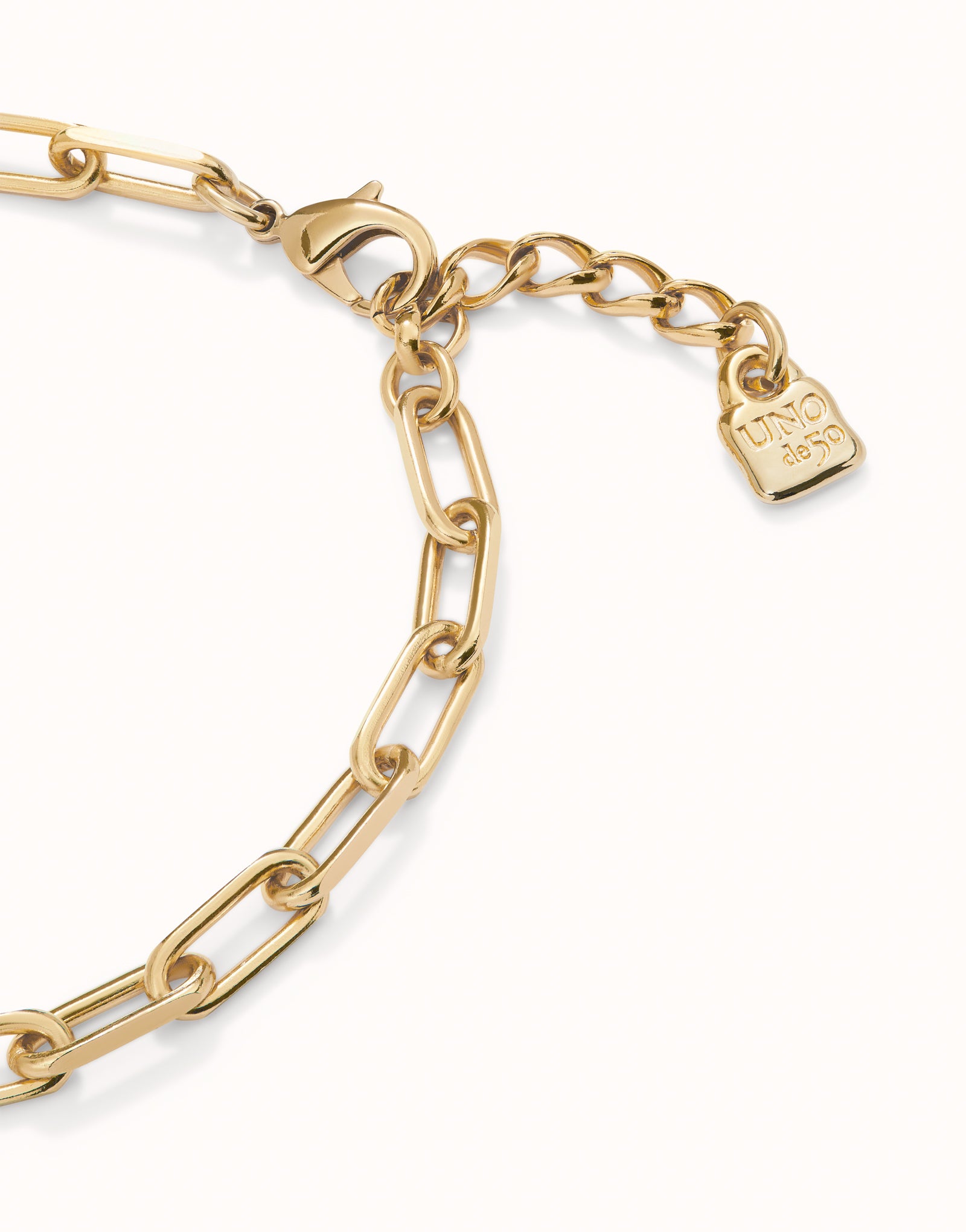 Gold short oval link chain necklace with elongated links, lobster clasp, adjustable extension, and "UNO de 50" engraved tag; handmade in the Ser Valiente collection with 18k gold plating. Available sizes: S, M, L.