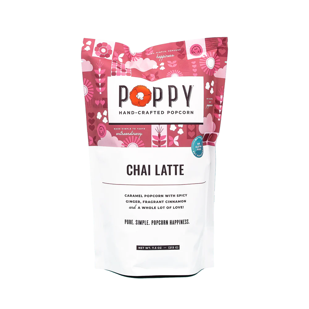 This is a packet of chai masala-flavored Poppy Popcorn. The packaging is colorful, dominated by pink and red floral designs. Flavor notes such as popcorn, ginger, cinnamon, and cardamom are prominently advertised on the label.