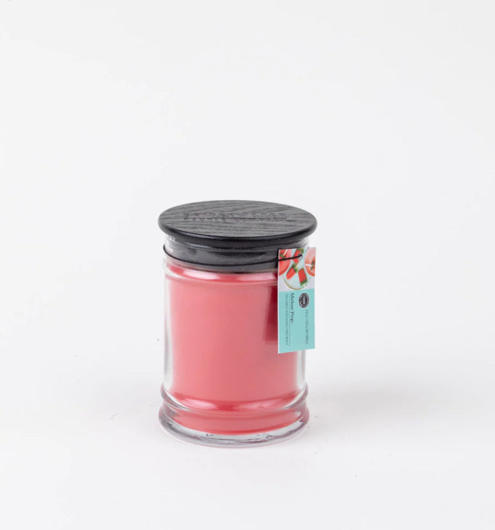 Melon Pop 8 oz candle: small jar, pink soy-blend wax, black lid, blue/pink watermelon tag, available in 8 oz size.