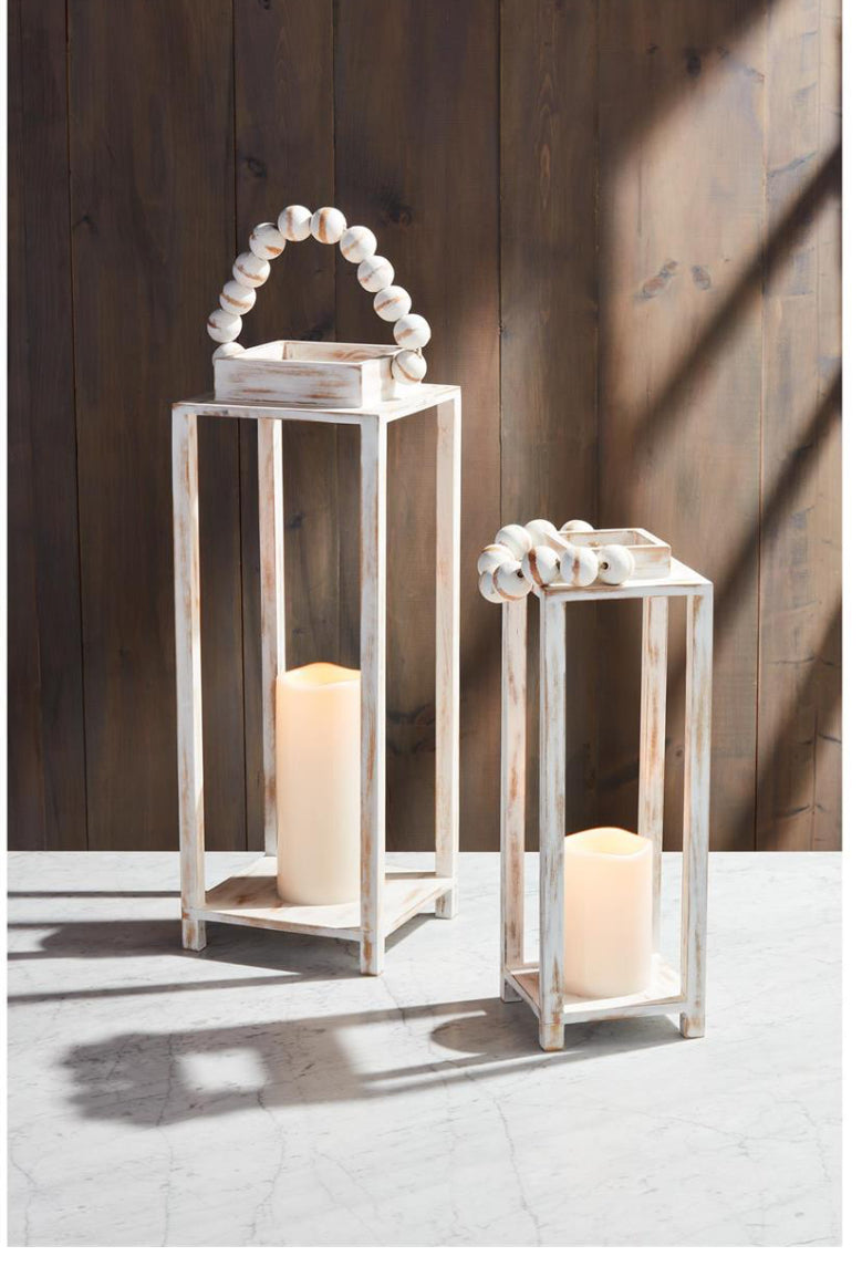 Set of white-washed mango wood lanterns with beaded handles; includes tall and short sizes; shown with candlelight.