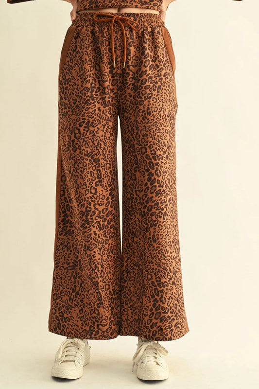 Leopard Contrast Pants with wide-leg silhouette, drawstring waist, and distinct leopard print pattern. Available in sizes XS–XL.