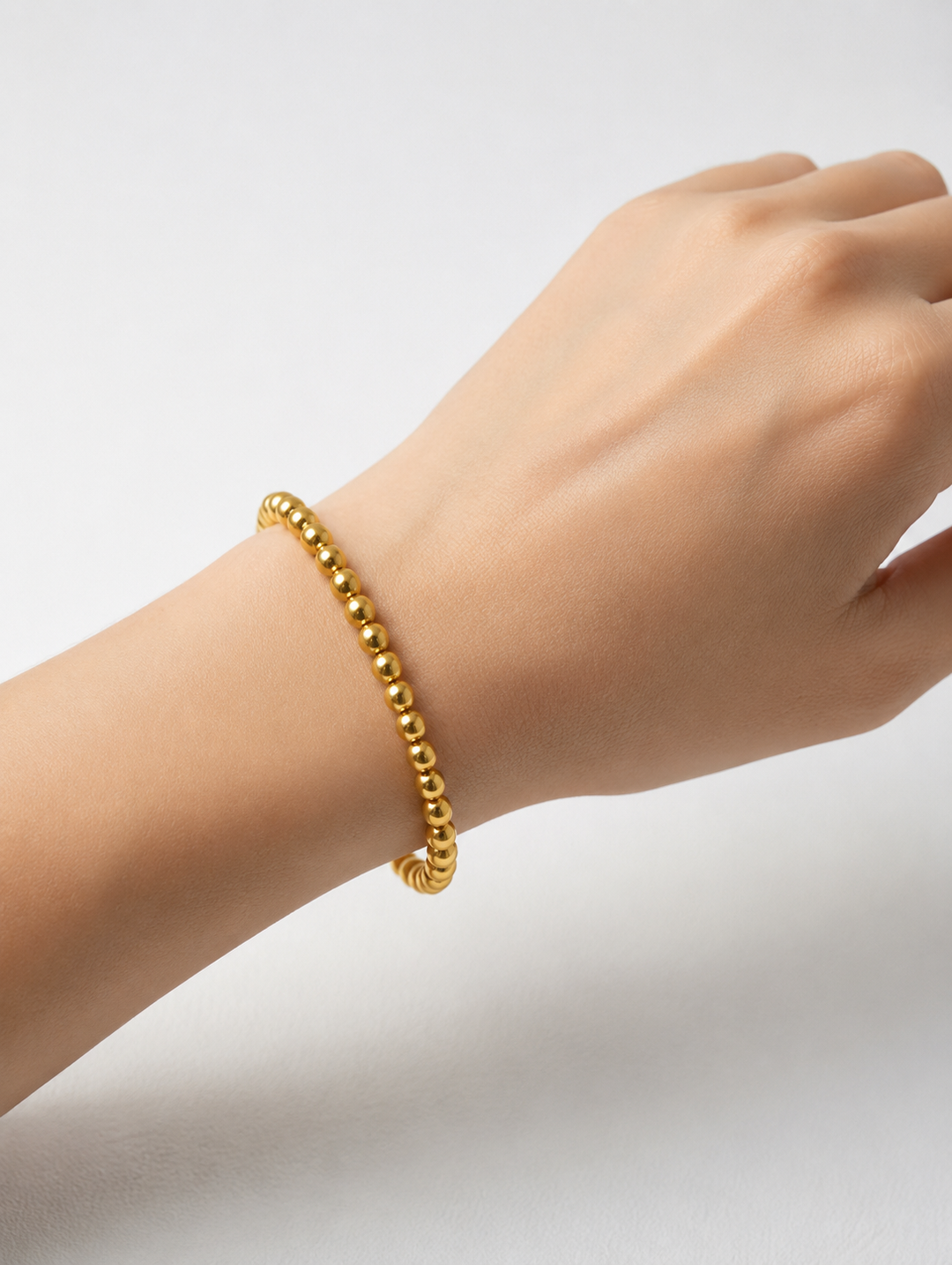 Water Resistant Beaded Stretch Bracelet with small round gold beads; available in S/M and M/L sizes.