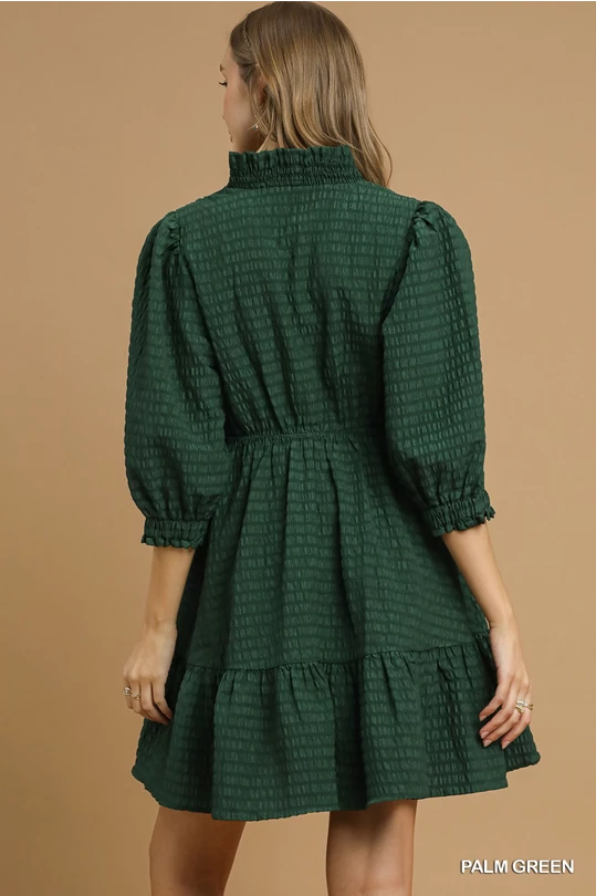 Palm Green Babydoll Dress with puffed 3/4 sleeves, ruffled high collar, and tiered skirt. Available in sizes XS-XL.