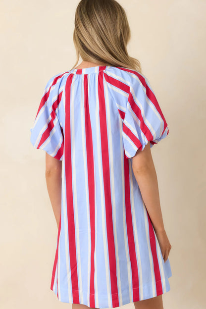 American Darling Stripe Dress with puff sleeves, vertical red, blue, and white stripes on beige. Available in sizes XS-XL.