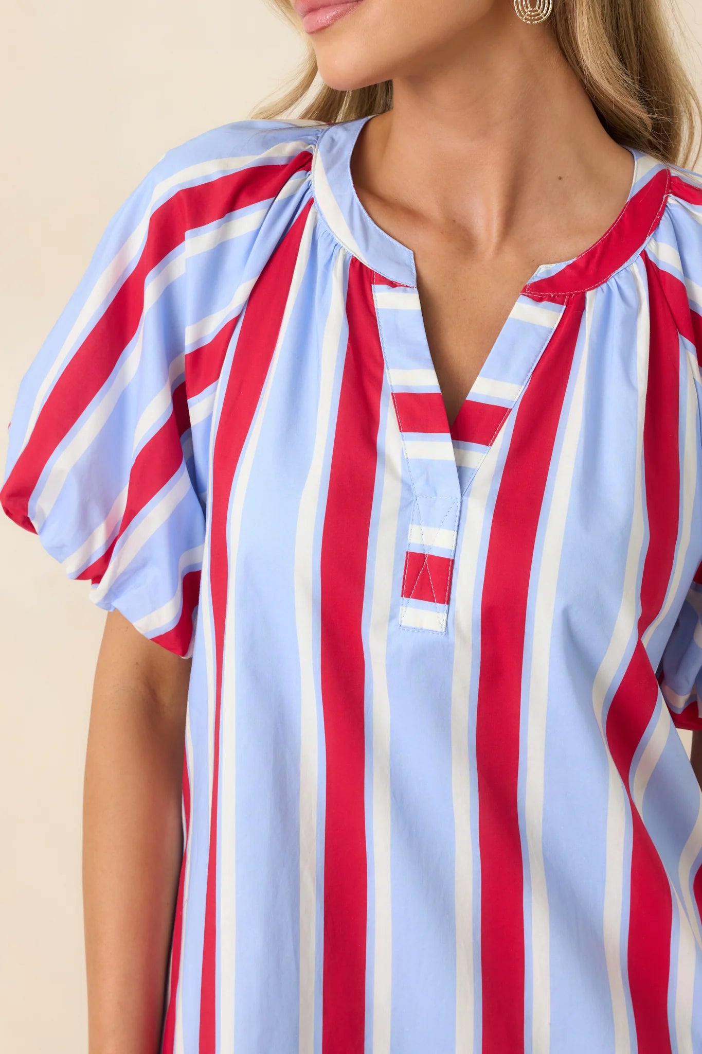 American Darling Stripe Dress with blue, red, and white vertical stripes, short puffed sleeves, split V-neck. Sizes: XS-XL.