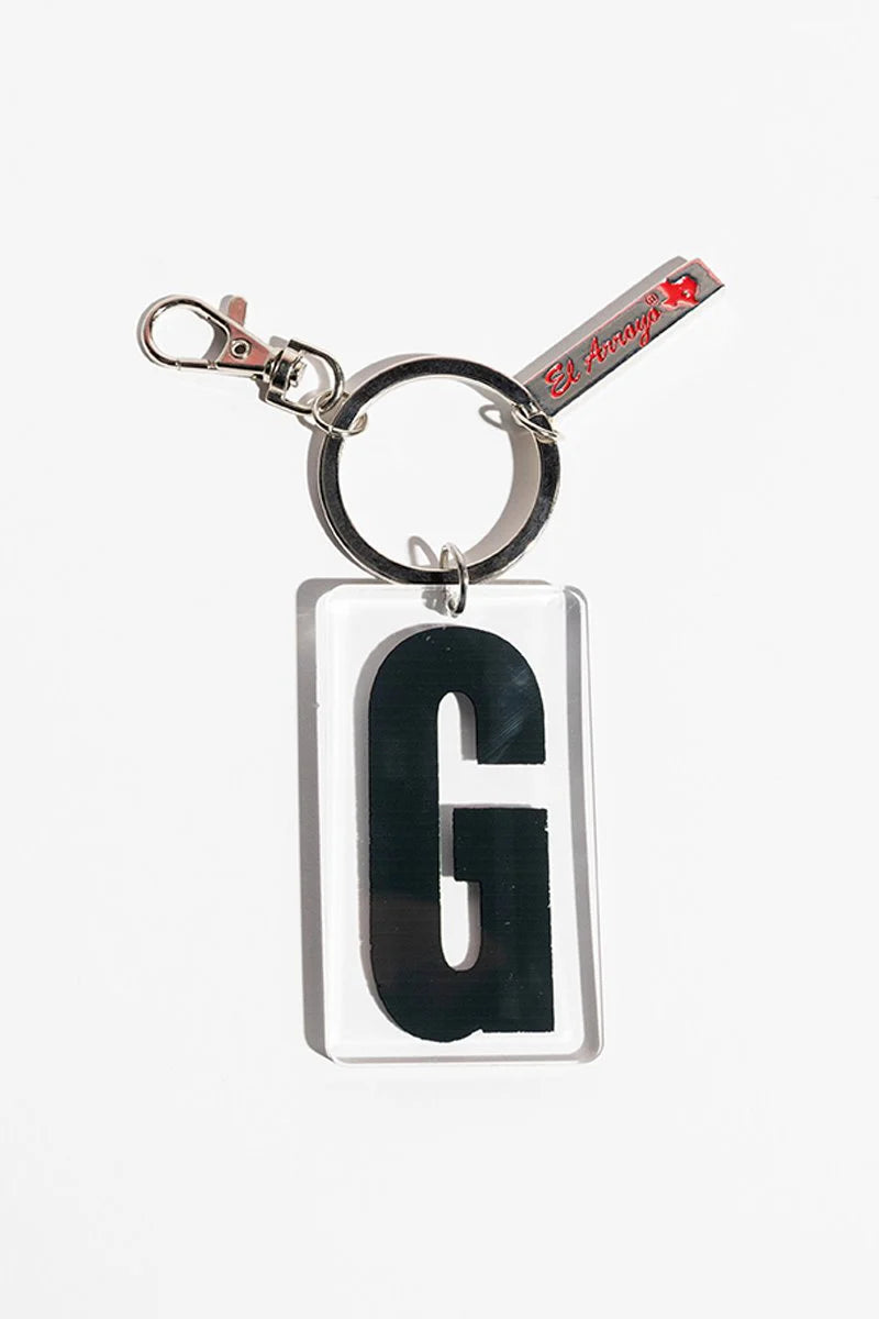 Clear acrylic keychain with black "G," sturdy metal clasp and ring, small red-letter tag. Available in multiple letter options.