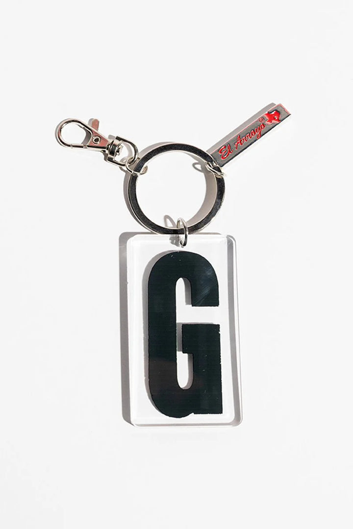 Clear acrylic keychain with black "G," sturdy metal clasp and ring, small red-letter tag. Available in multiple letter options.