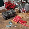 Spool of red Christmas ribbon with white “Merry Christmas” text.
