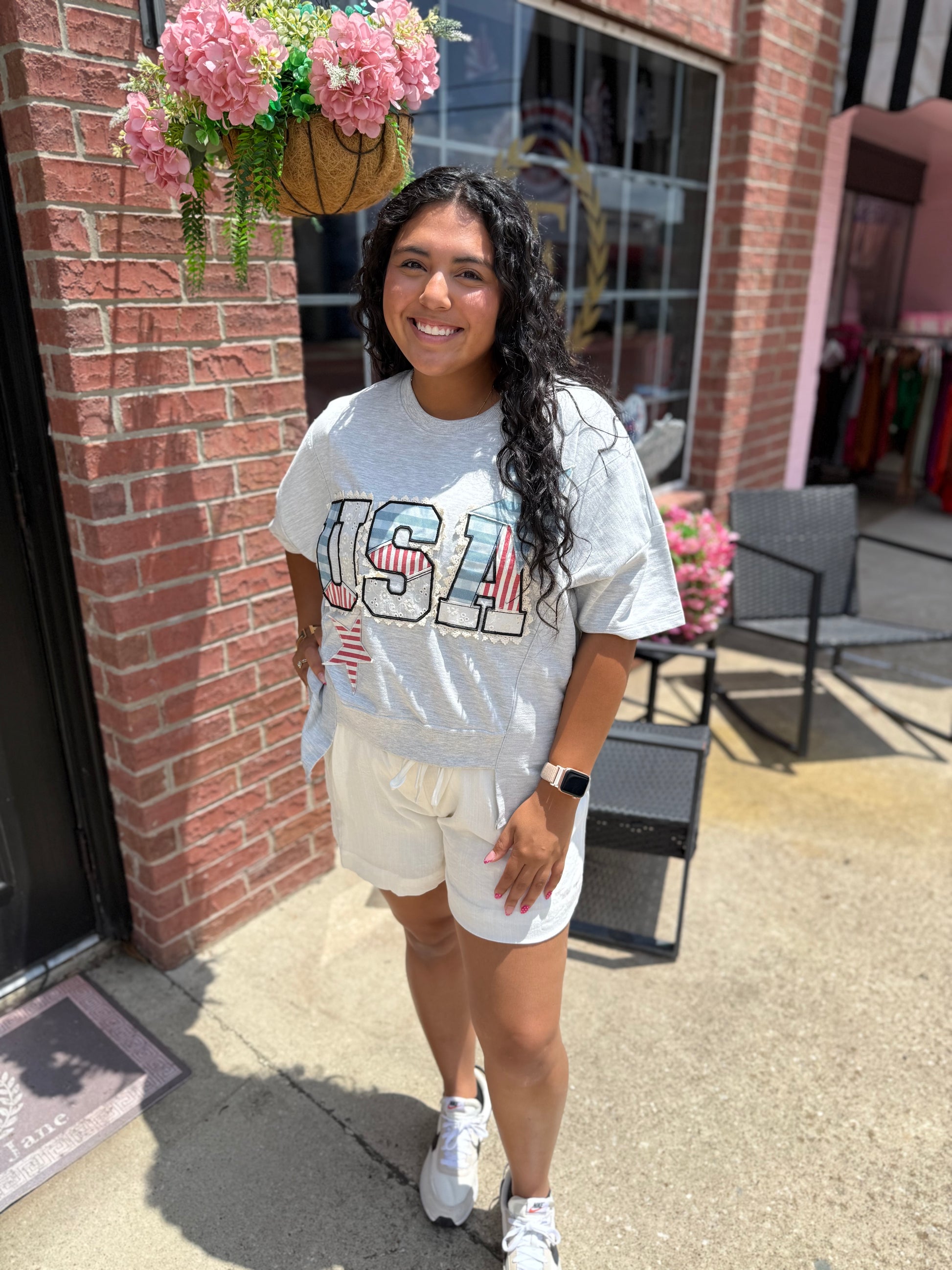 Light gray USA Patch Tee. Available in sizes XS–XL.